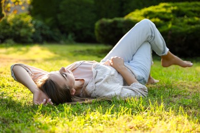 Photo of Woman resting on green lawn in park