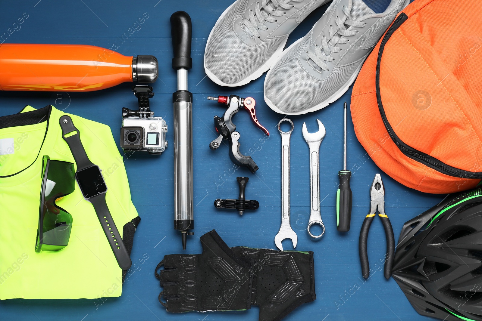 Photo of Bicycle accessories and tools on blue wooden background, flat lay