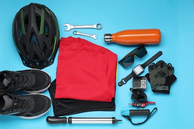 Photo of Bicycle accessories and equipment on light blue background, flat lay