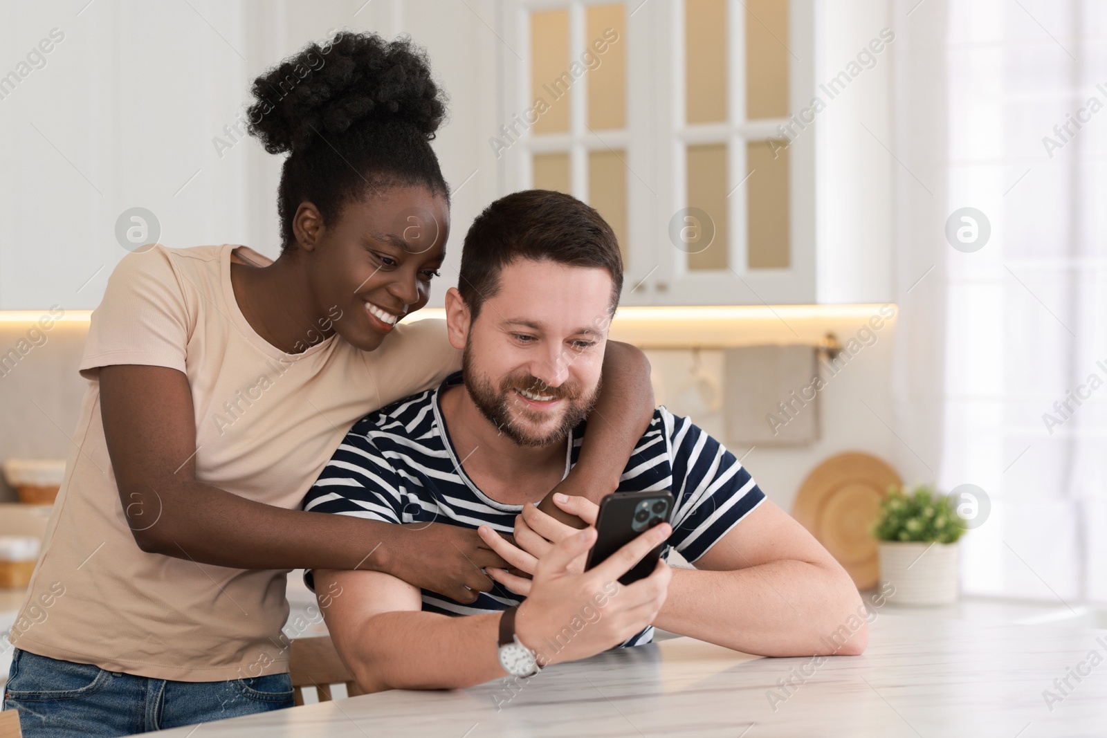 Photo of International relationships. Lovely couple spending time together in kitchen