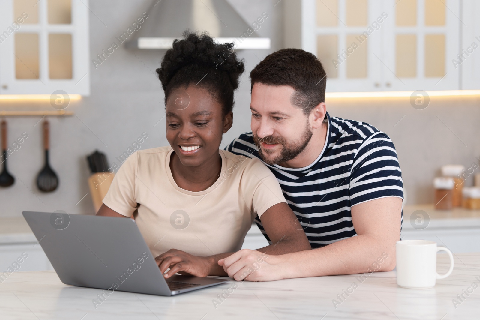 Photo of International relationships. Lovely couple spending time together in kitchen