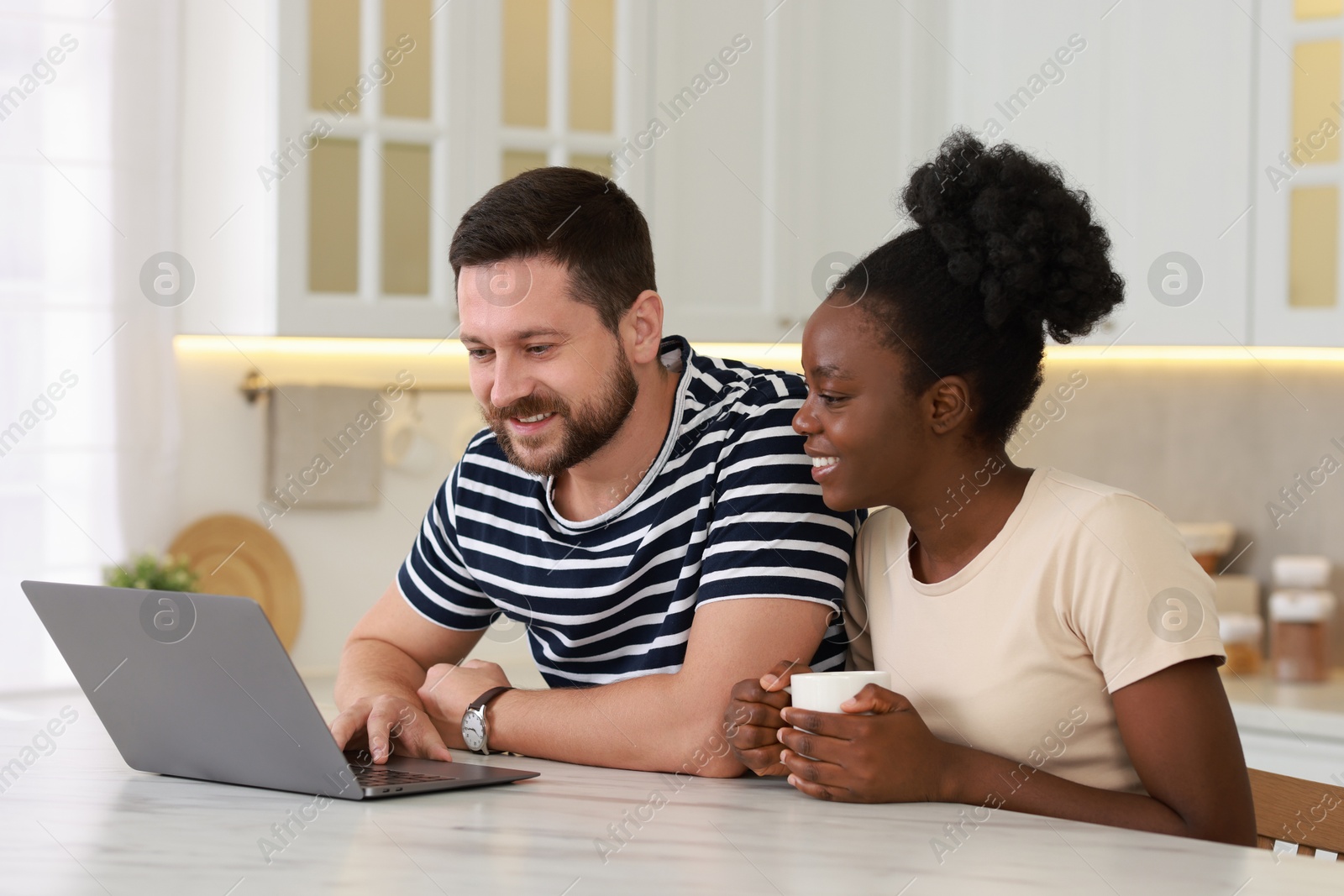 Photo of International relationships. Lovely couple spending time together in kitchen