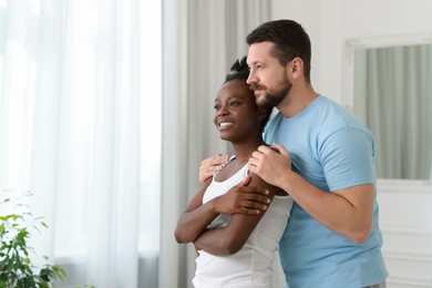 International relationships. Portrait of lovely couple at home, space for text