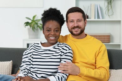 International relationships. Portrait of lovely couple on sofa at home