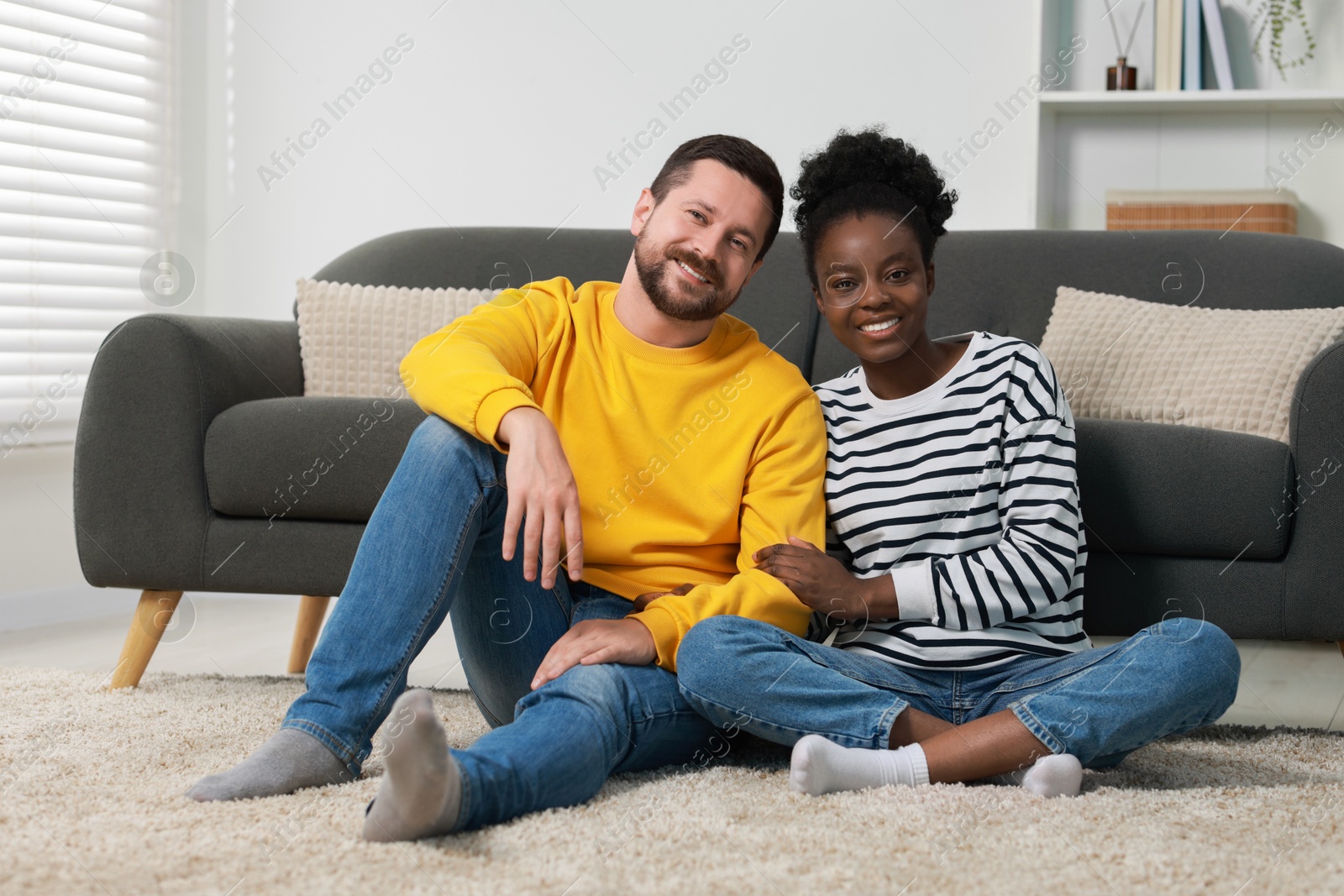 Photo of International relationships. Lovely couple spending time together on floor at home