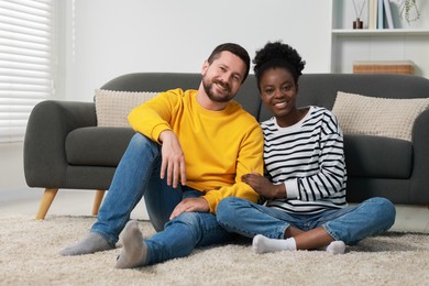 International relationships. Lovely couple spending time together on floor at home