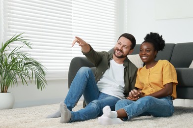 Photo of International relationships. Lovely couple spending time together on floor at home