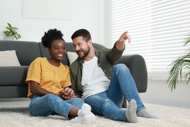 International relationships. Lovely couple spending time together on floor at home