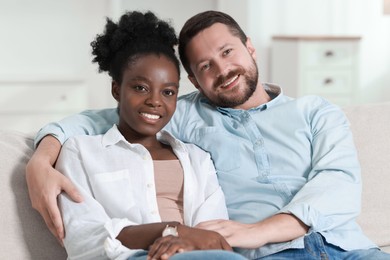 International relationships. Portrait of lovely couple on sofa at home