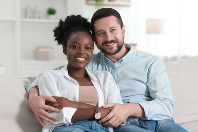 Photo of International relationships. Portrait of lovely couple on sofa at home