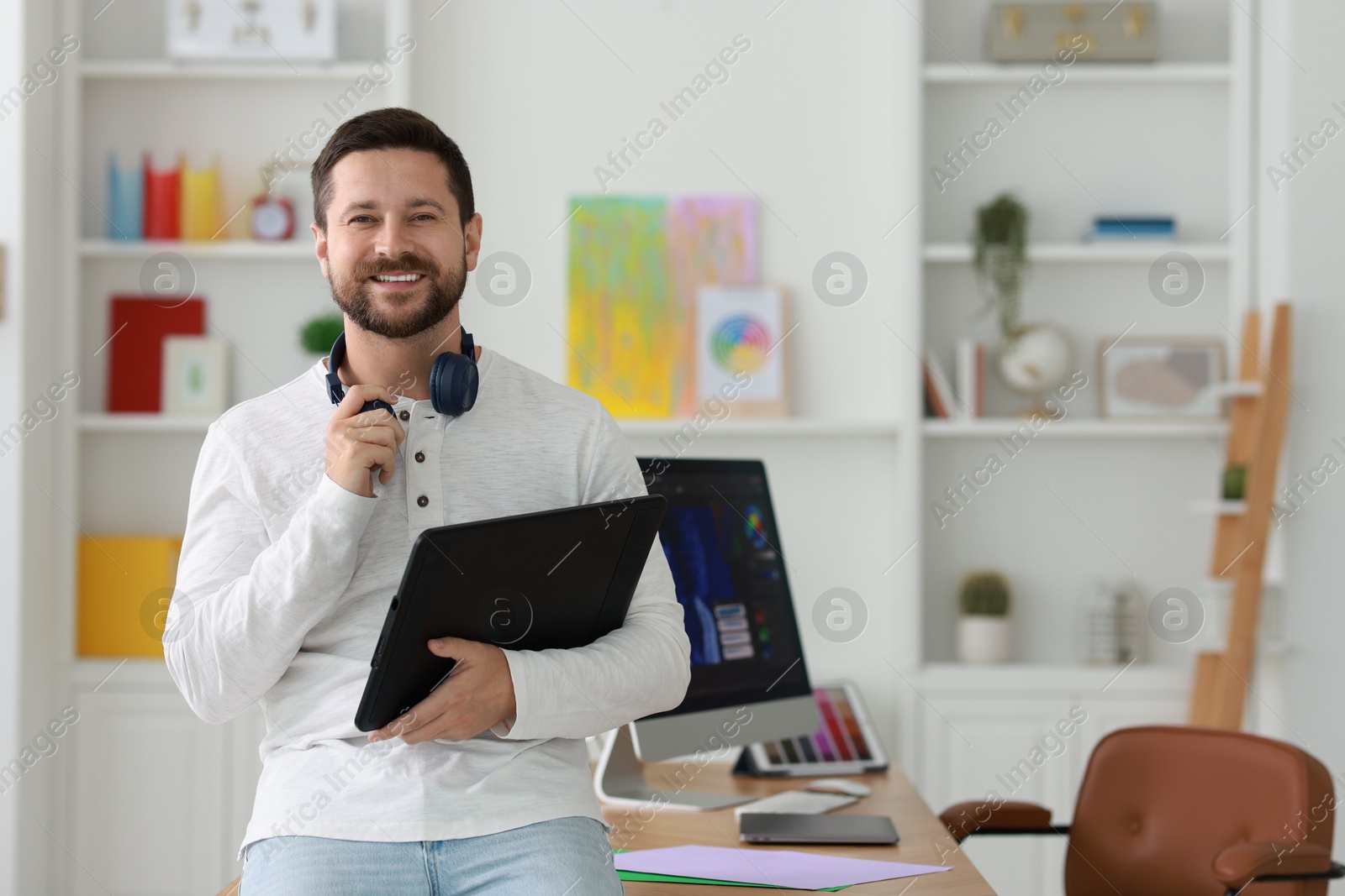 Photo of Smiling designer with tablet in office, space for text