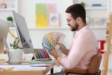 Designer working with color samples at table in office