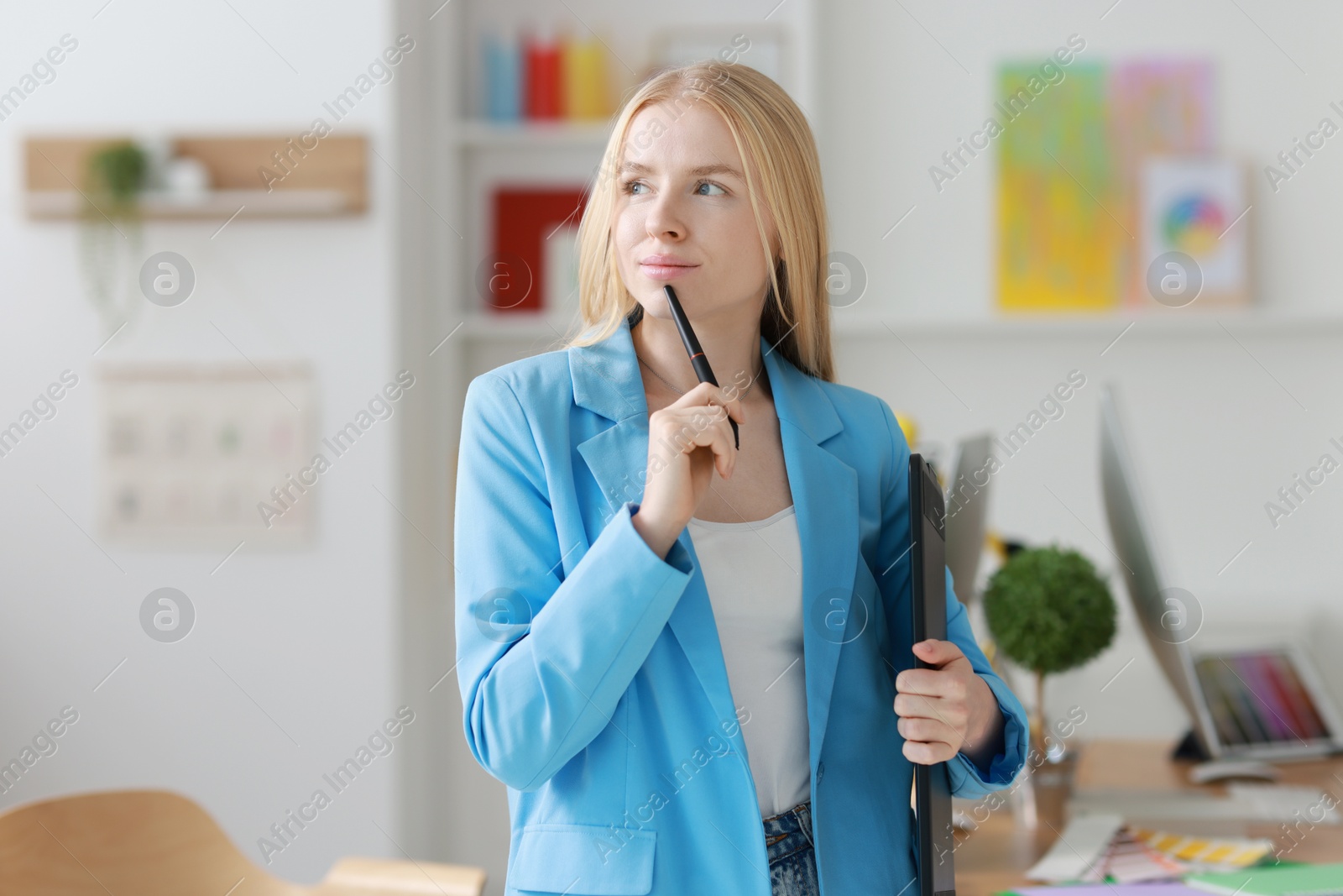 Photo of Beautiful young designer with tablet in office