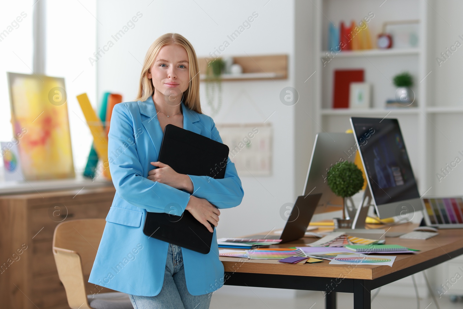 Photo of Beautiful young designer with tablet in office