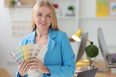 Young designer with color samples in office