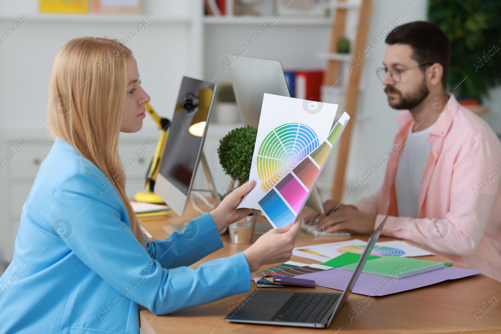 Photo of Designers working at table in office, selective focus