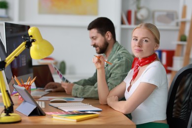 Designers working together at table in office, selective focus