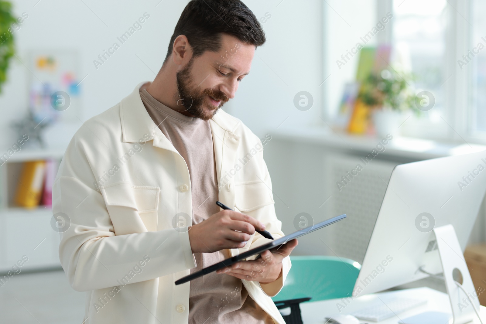 Photo of Professional designer with tablet working in office