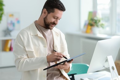 Photo of Professional designer with tablet working in office