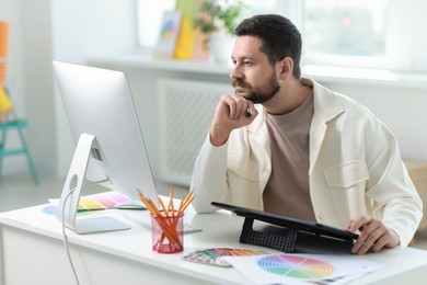 Designer working with tablet at table in office