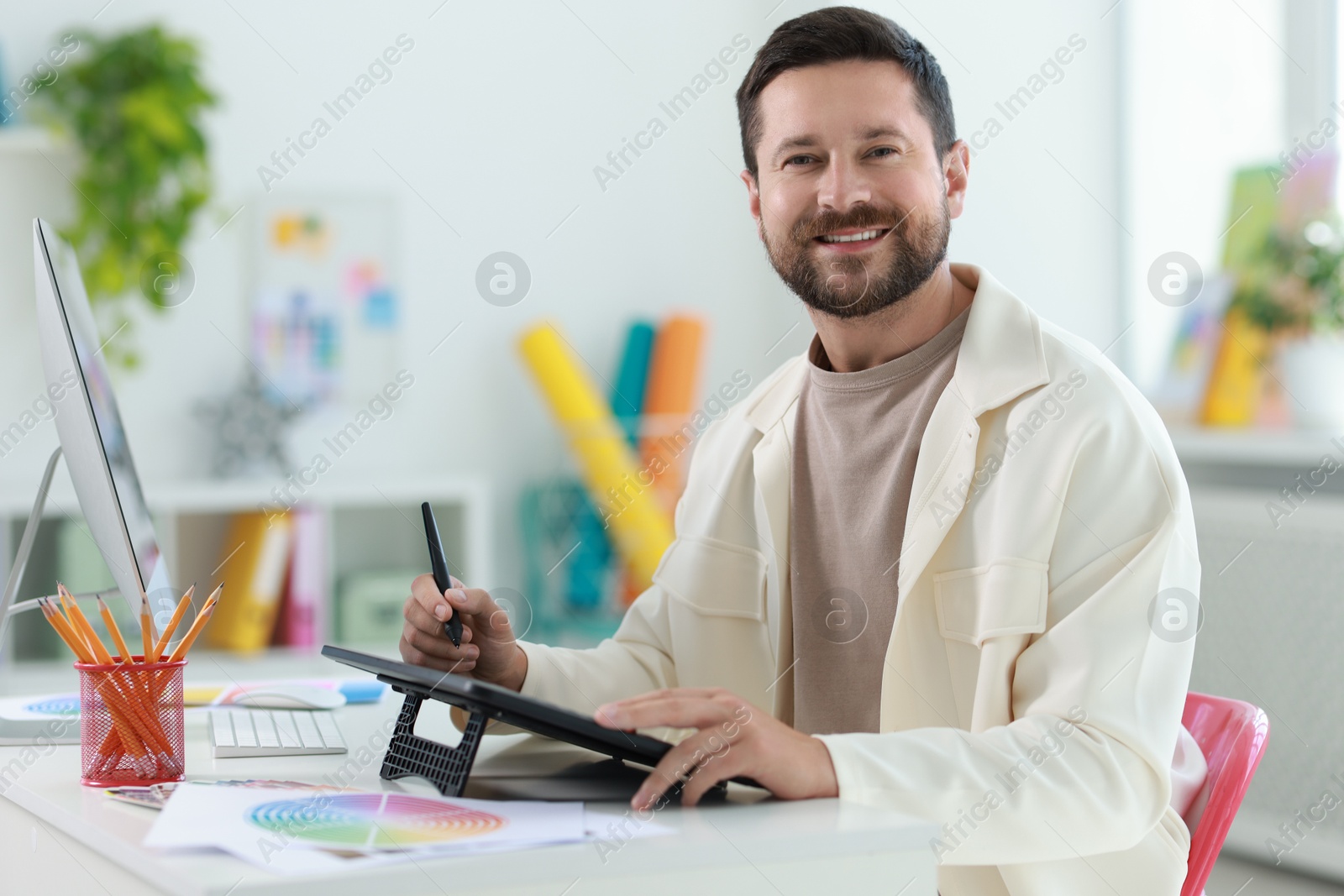 Photo of Designer working with tablet at table in office