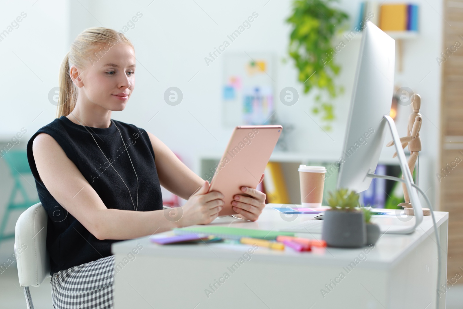 Photo of Designer working with tablet at table in office