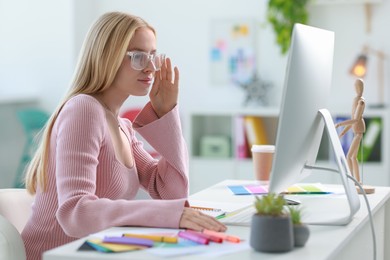 Designer working with computer at table in office