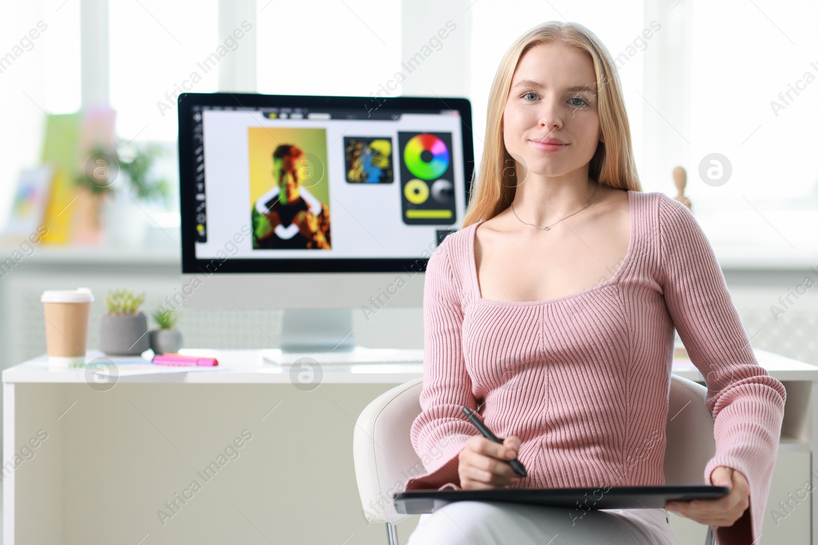 Photo of Beautiful young designer with tablet in office