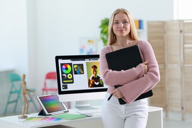 Photo of Beautiful young designer with tablet in office