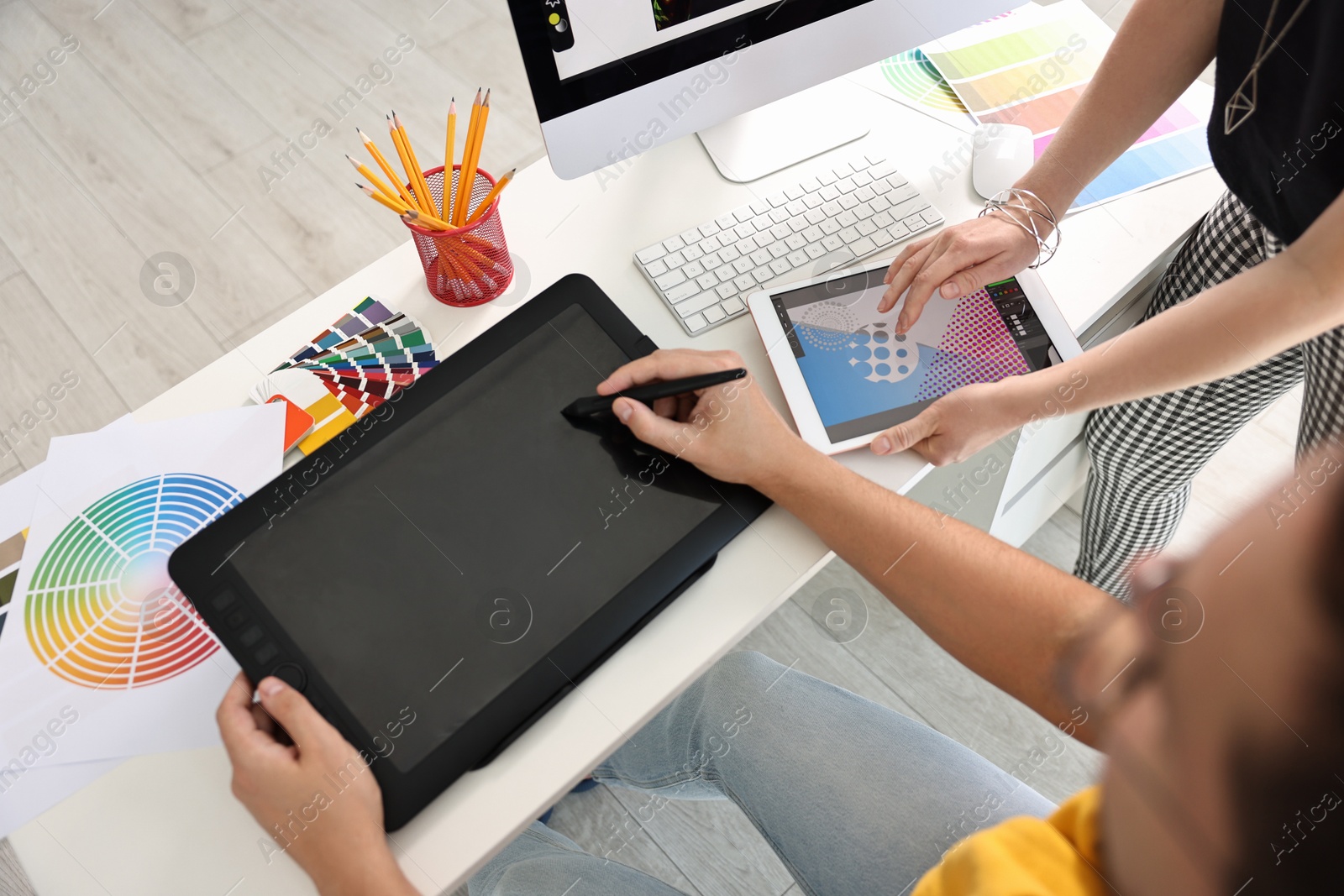 Photo of Designers working together with tablets at table in office, closeup