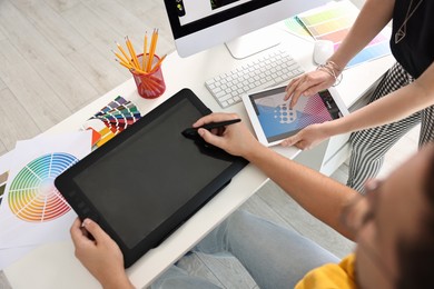 Designers working together with tablets at table in office, closeup