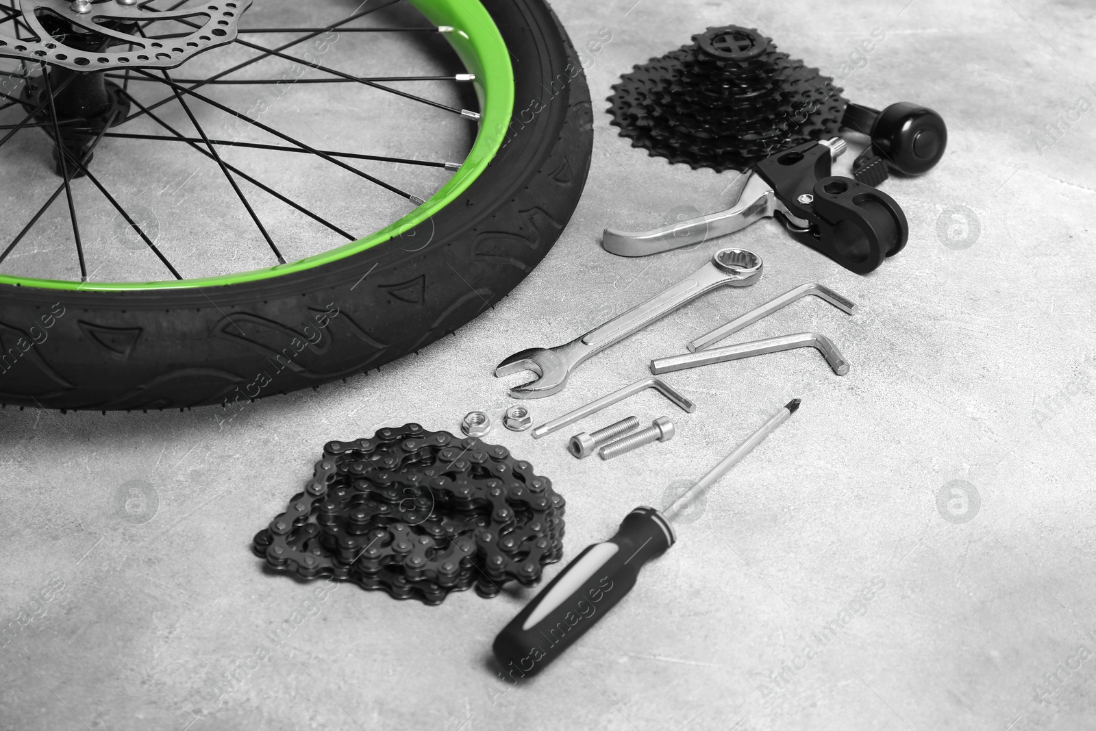 Photo of Parts of bicycle and tools on grey background, closeup