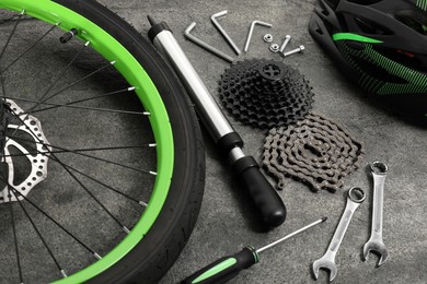 Parts of bicycle and tools on grey background