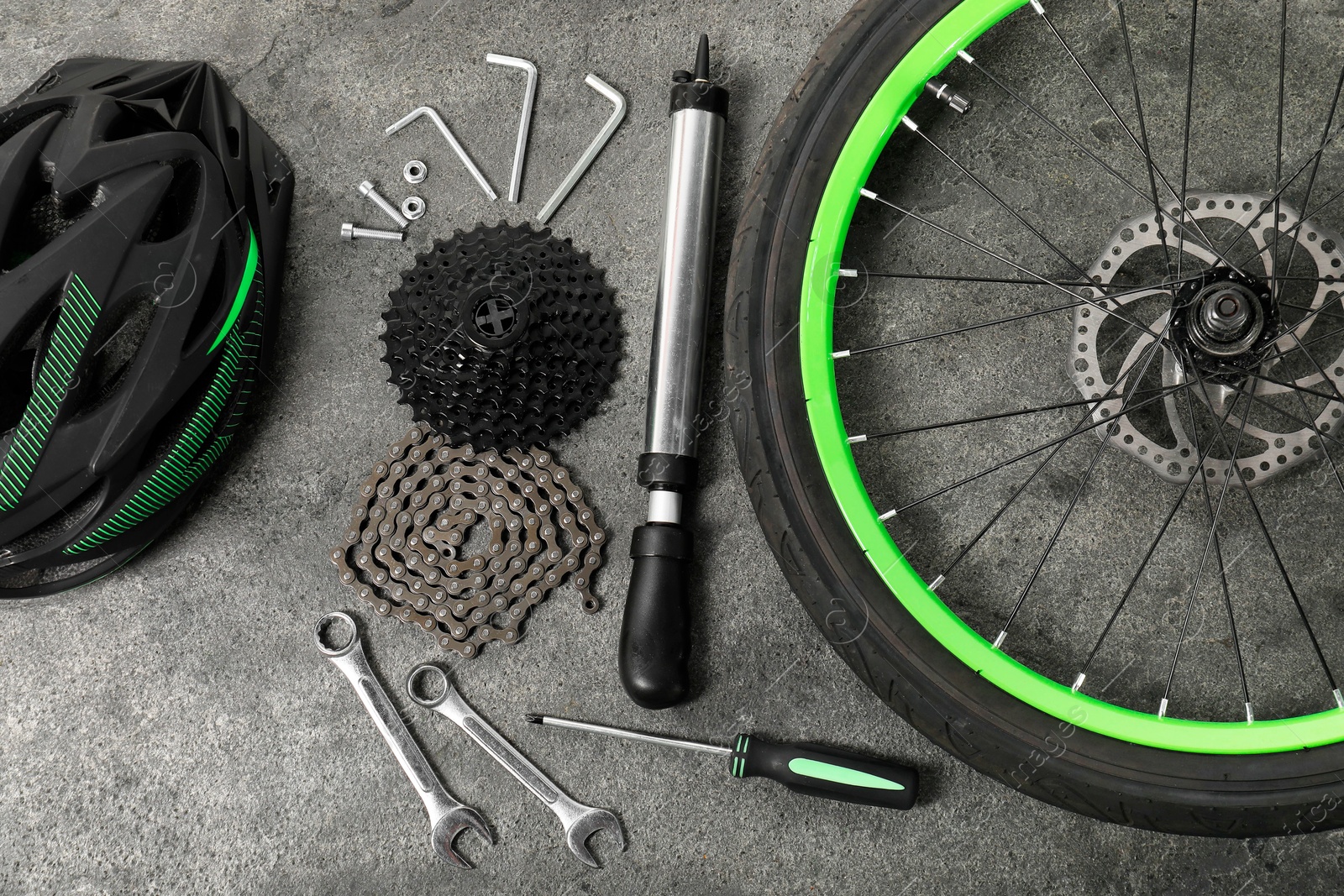 Photo of Parts of bicycle and tools on grey background, flat lay