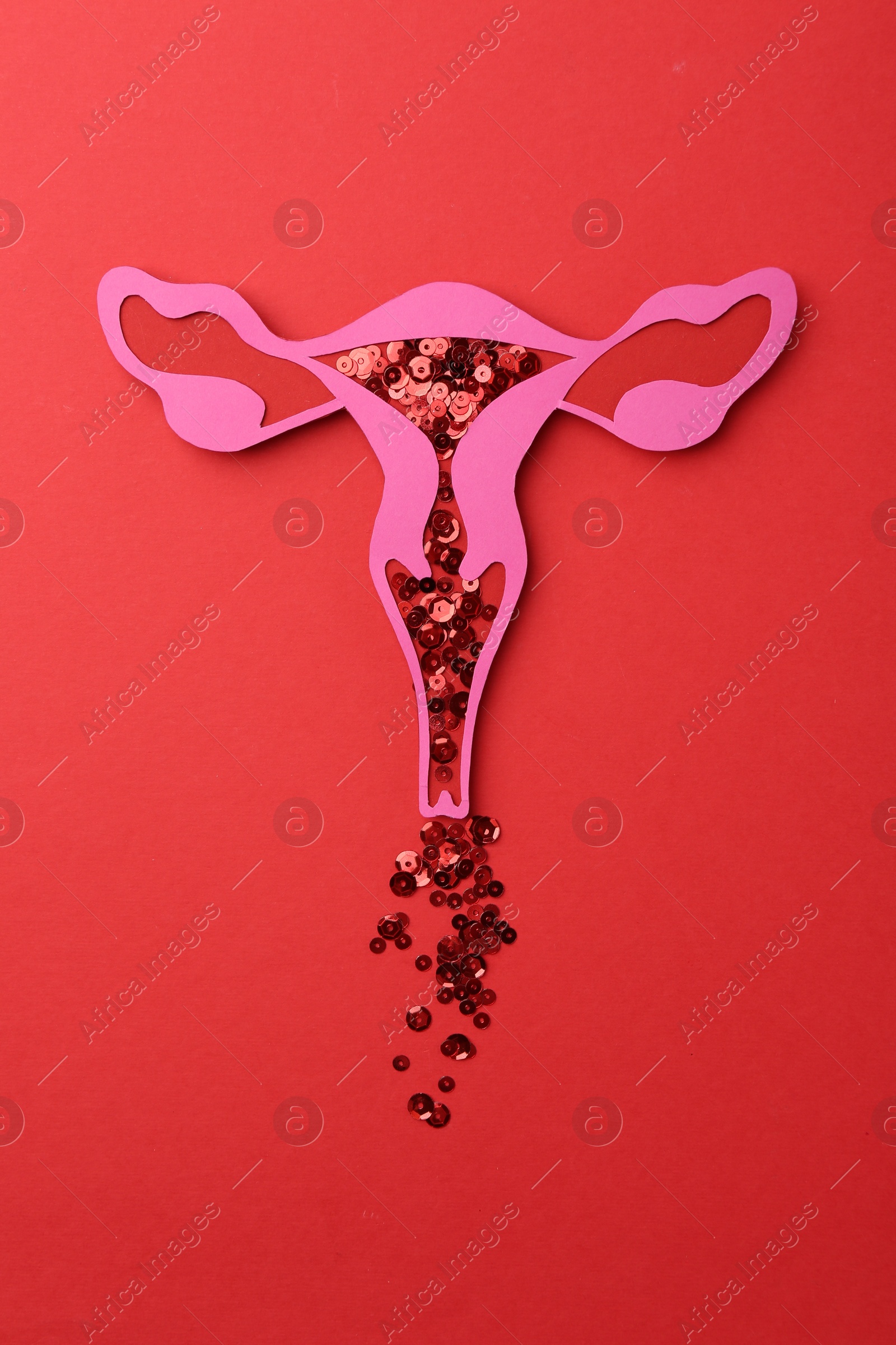 Photo of Menstruation. Paper uterus with sequins on red background, top view