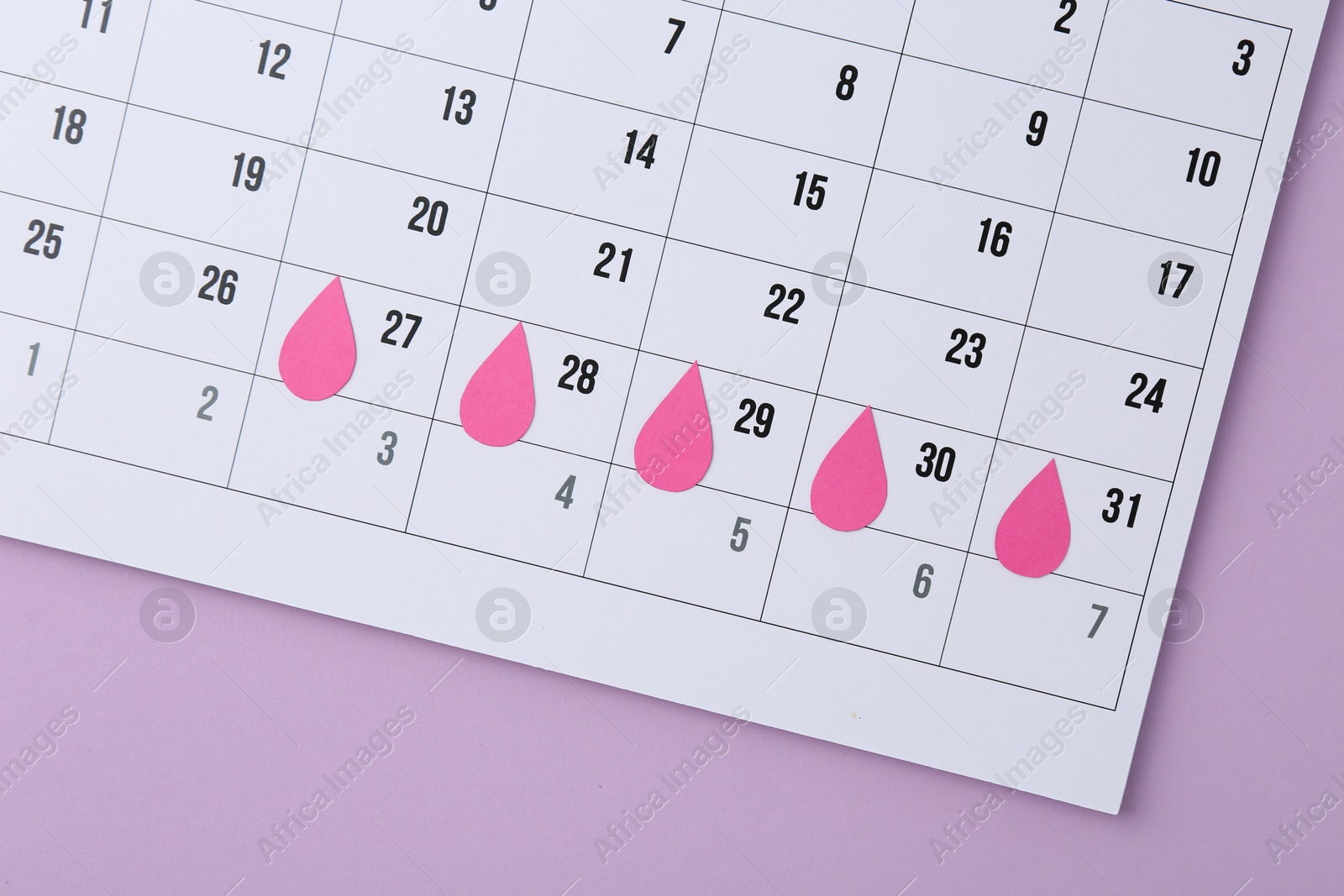 Photo of Menstruation. Calendar with marked dates on violet background, top view