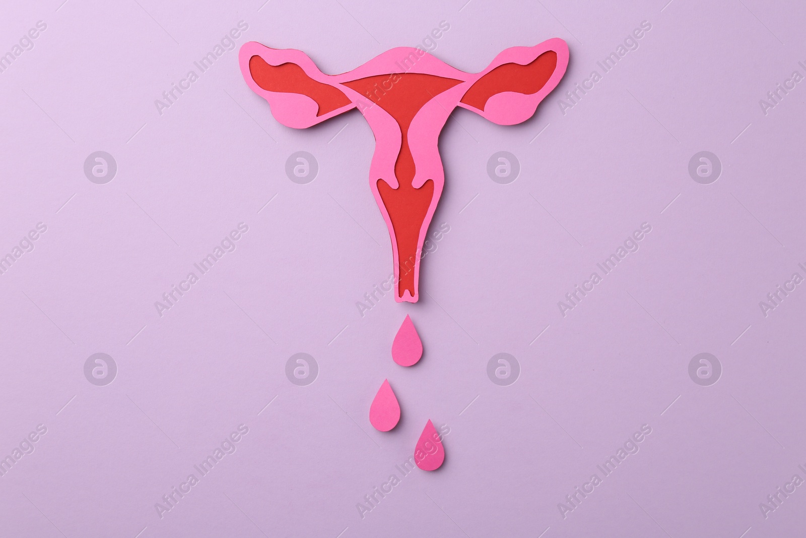 Photo of Menstruation. Paper uterus with drops on violet background, top view