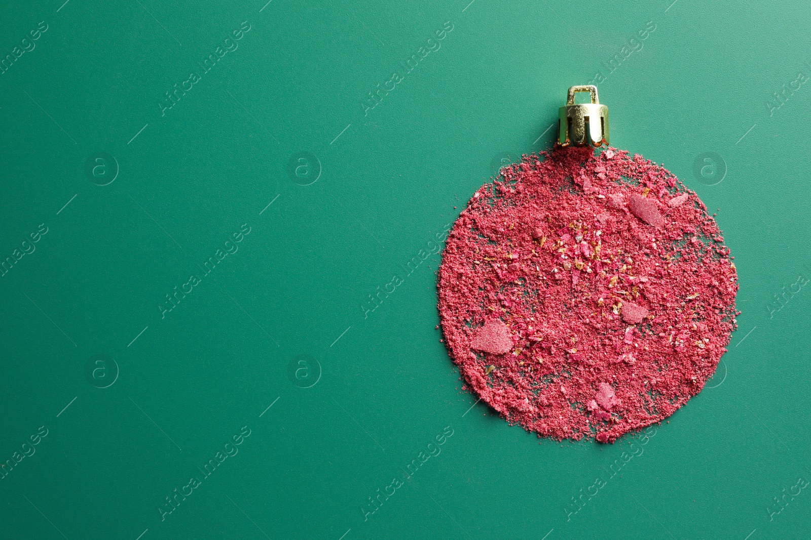 Photo of Christmas ball made of blush on green background, top view. Space for text