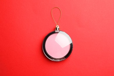 Photo of Blusher in shape of Christmas ball on red background, top view