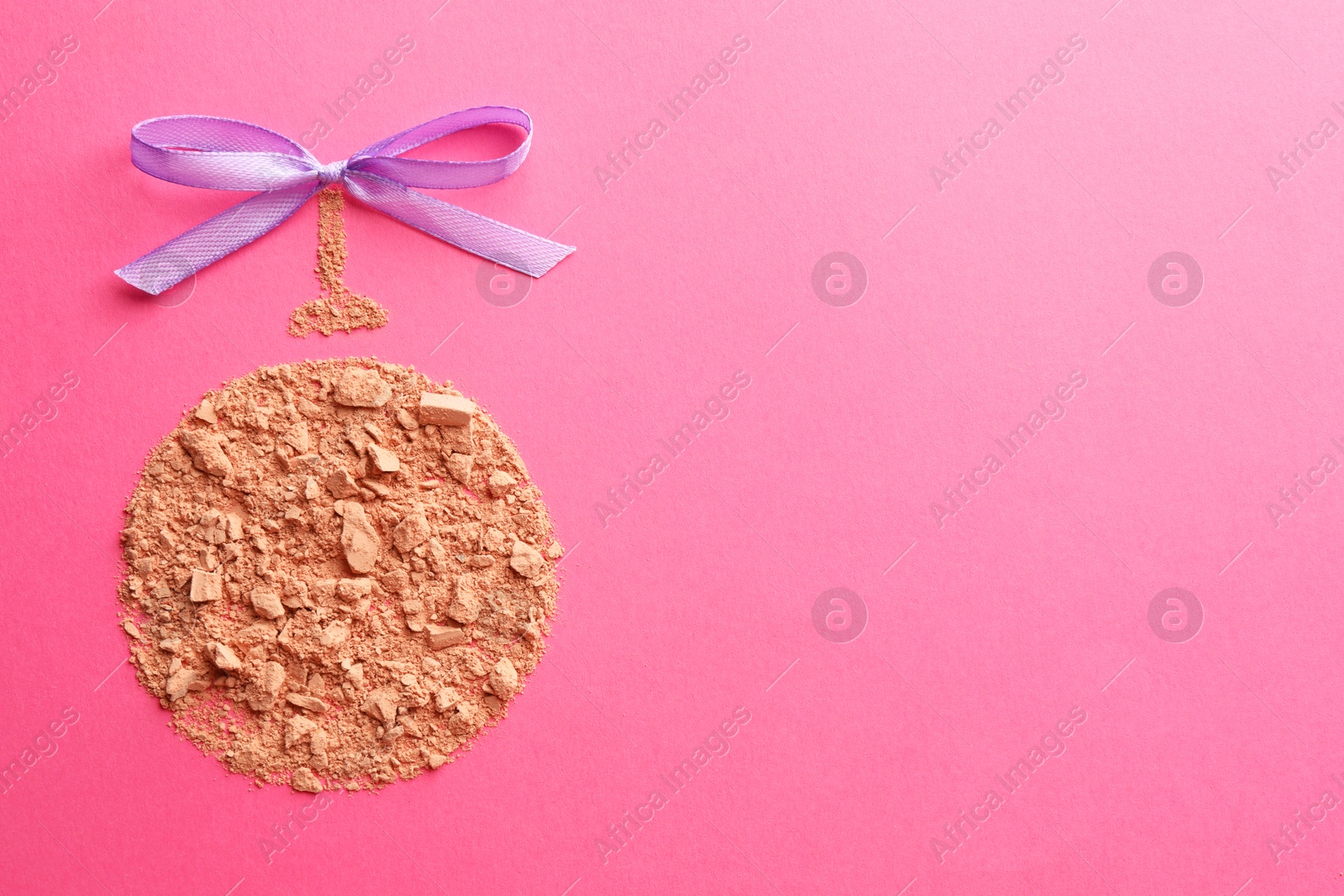 Photo of Christmas ball made with face powder on pink background, top view. Space for text