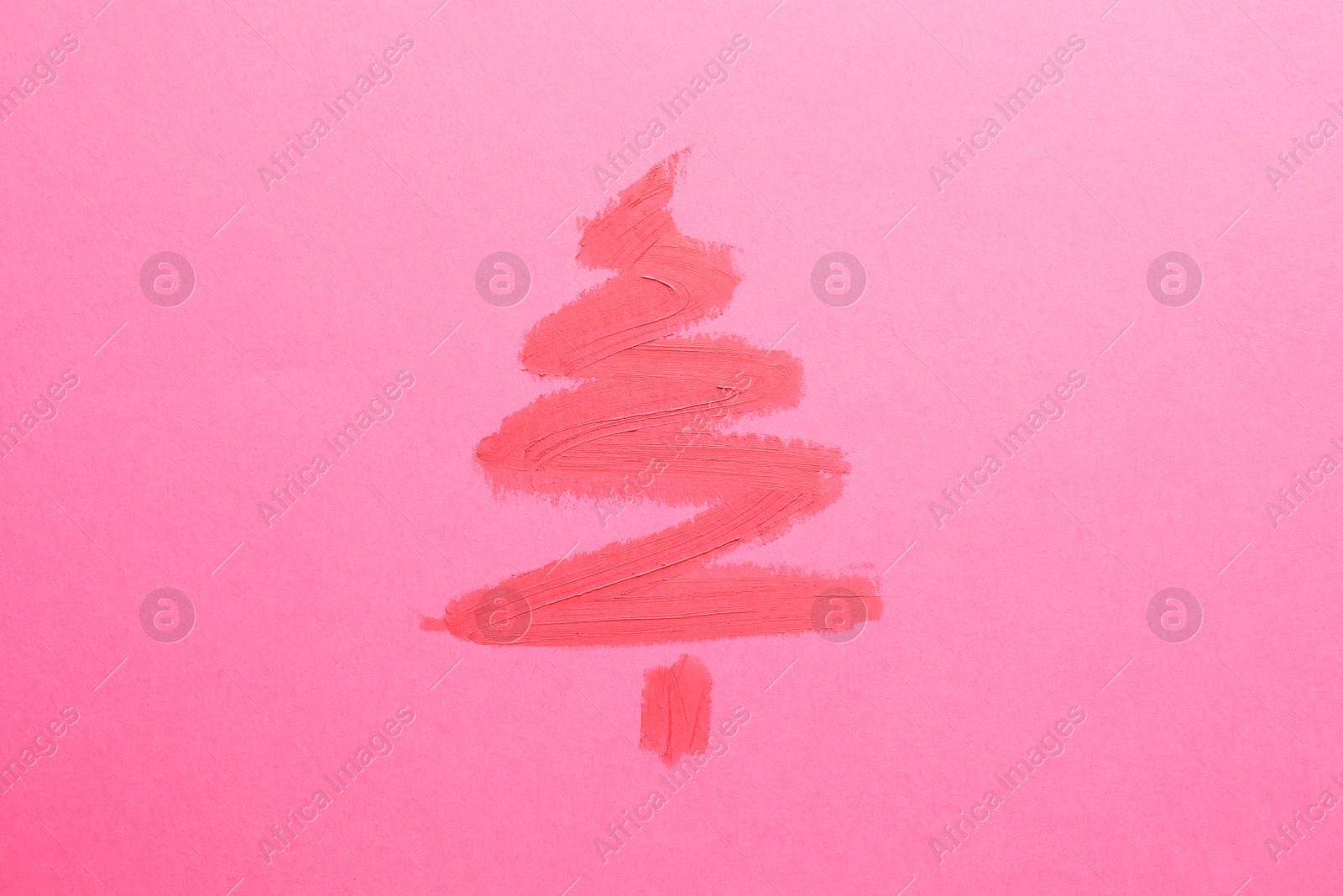 Photo of Christmas tree drawn with lipstick on pink background, top view