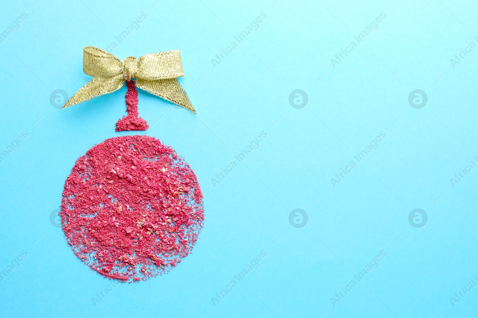 Photo of Christmas ball made with blush on light blue background, top view. Space for text