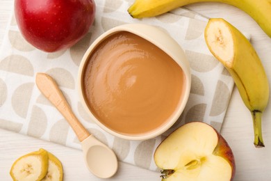 Photo of Delicious baby food in bowl and ingredients on white wooden table, flat lay