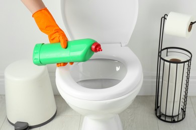 Photo of Woman with detergent cleaning toilet seat in bathroom, closeup