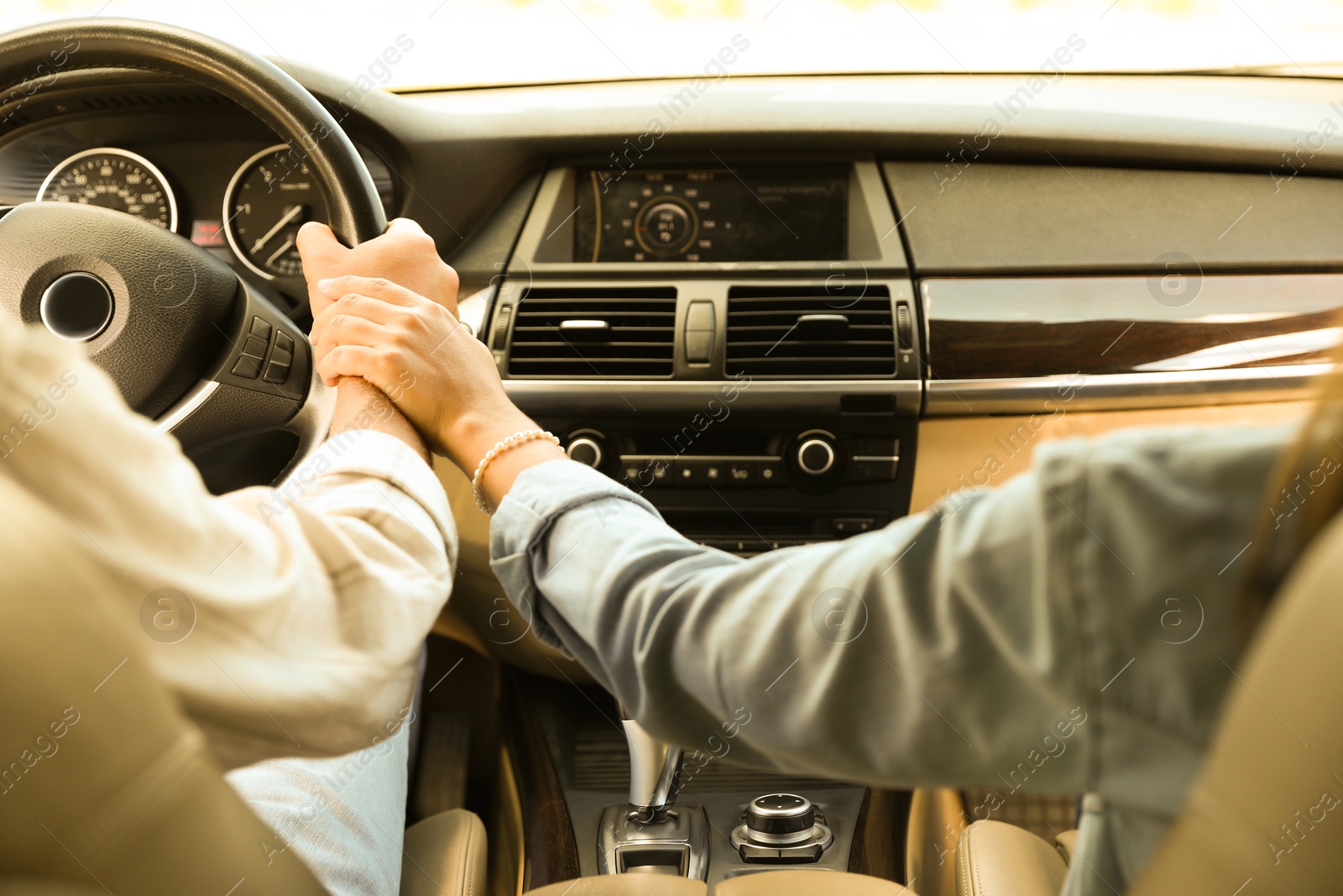 Photo of Lovely couple holding hands together while traveling by car, closeup