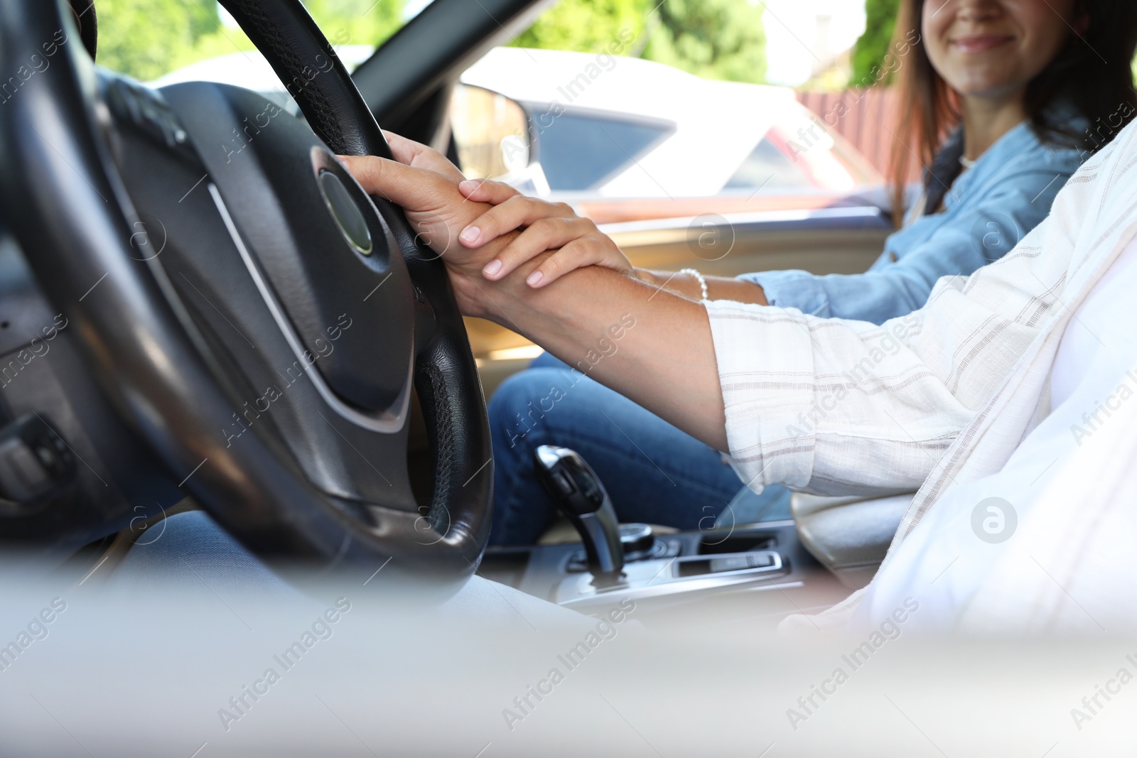 Photo of Lovely couple holding hands together while traveling by car, closeup