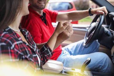 Lovely couple holding hands together while traveling by car, closeup