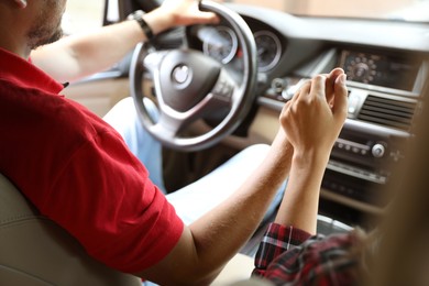 Lovely couple holding hands together while traveling by car, closeup