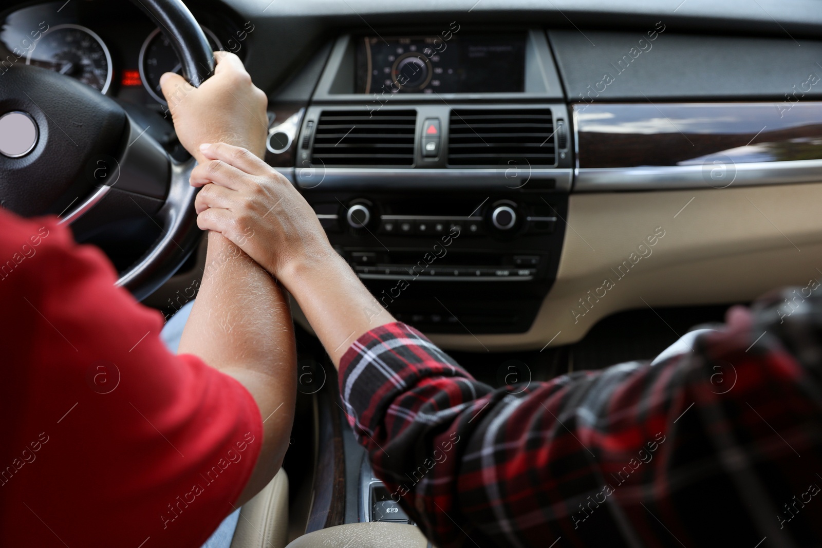 Photo of Lovely couple holding hands together while traveling by car, closeup