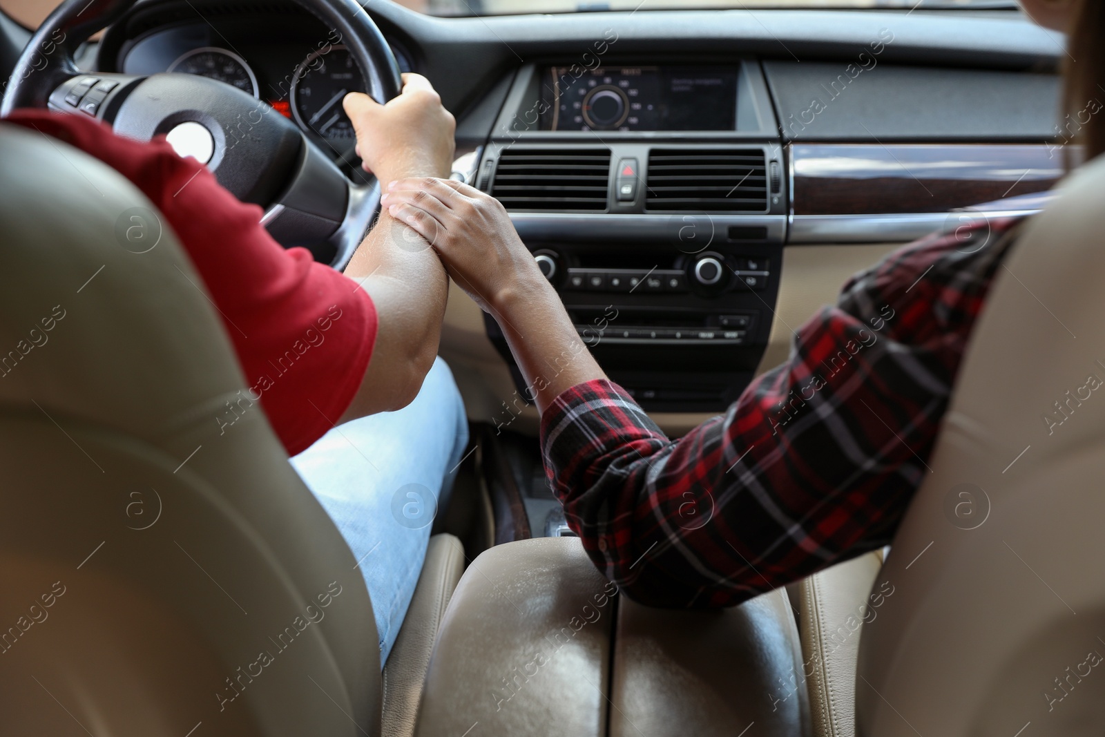 Photo of Lovely couple holding hands together while traveling by car, closeup